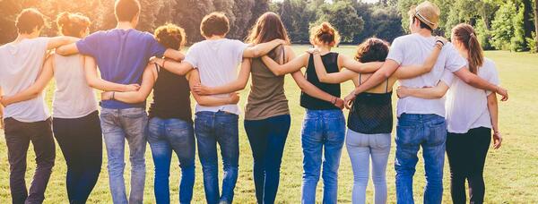 Students walking in a group embrace.